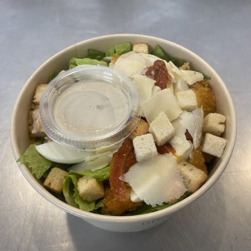 Salade César, tomate, oeuf, crouton, pot de sauce césar, dans un bol à emporter